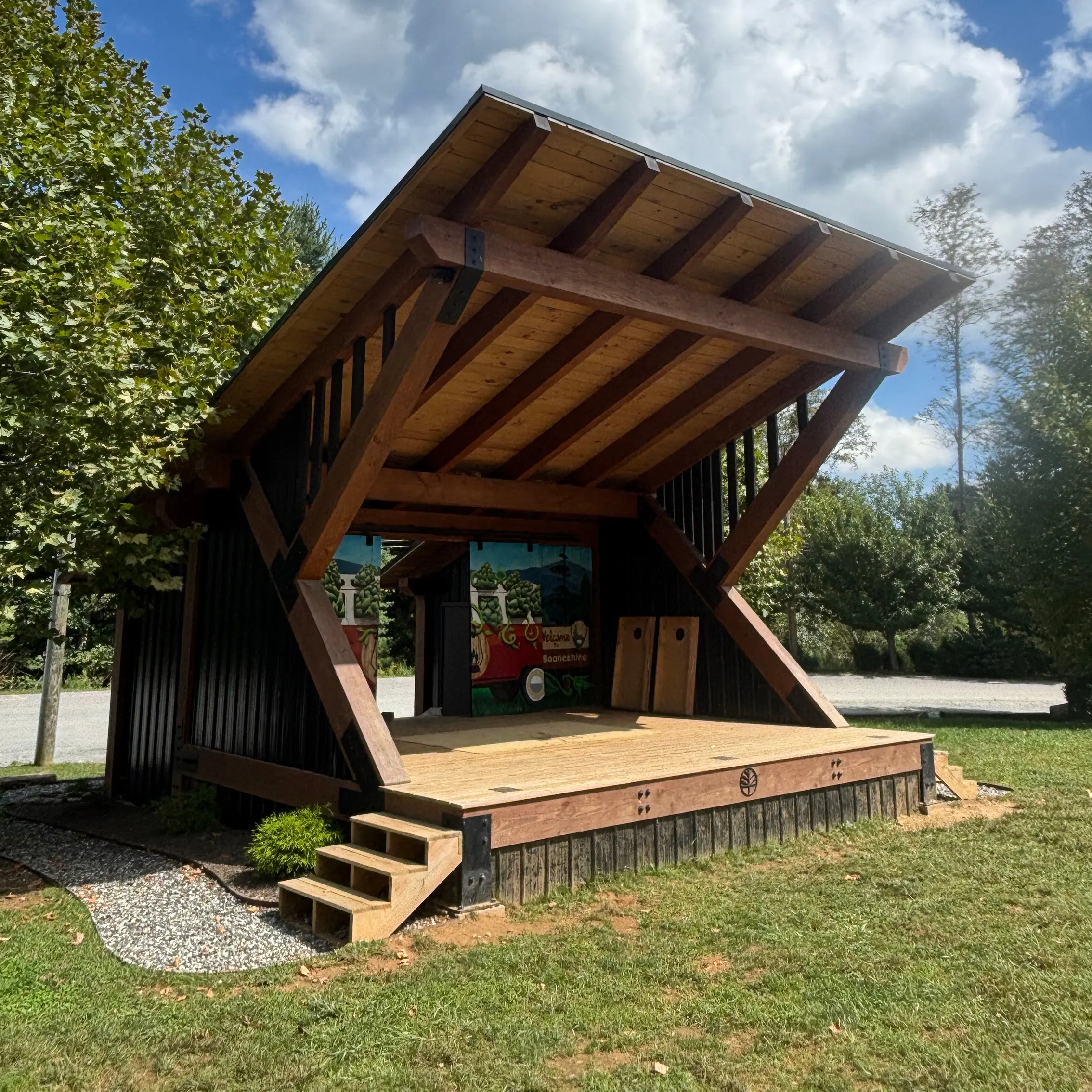 Booneshine Stage, a heavy timber-frame performance stage with a single-slope roof and elevated wood deck in Boone, NC.